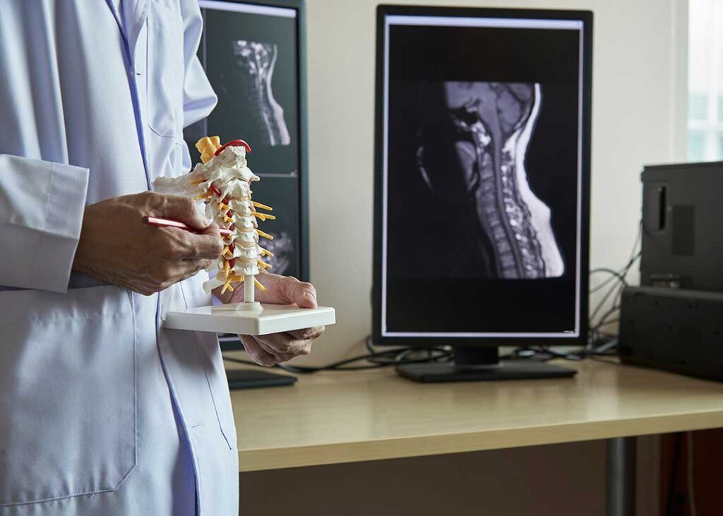 Adult discussing back pain with a clinician during a careful spine and posture assessment.